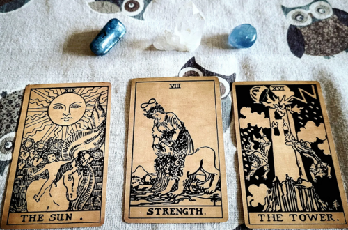 Tarot oplæg der viser The Sun, Strength og The Tower. Bagved er der to blå krystaller og en bjergkrystal.