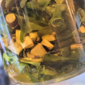 Close up af sylteglas med mælkebøtte stykker i olie