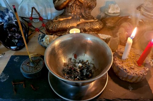 Heksekedel på alter med stearinlys og røgelse