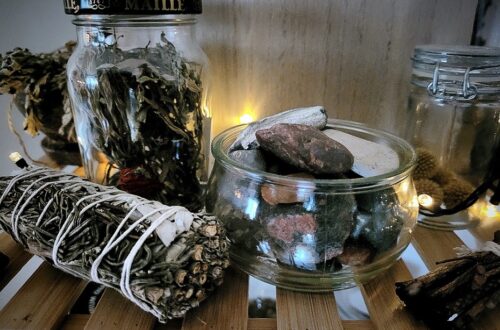Røgelse og smudge sammen med glas med sten og tørrede urter.