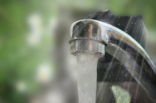 Billedcollage med løbende vandhane med blomster på græs som baggrund