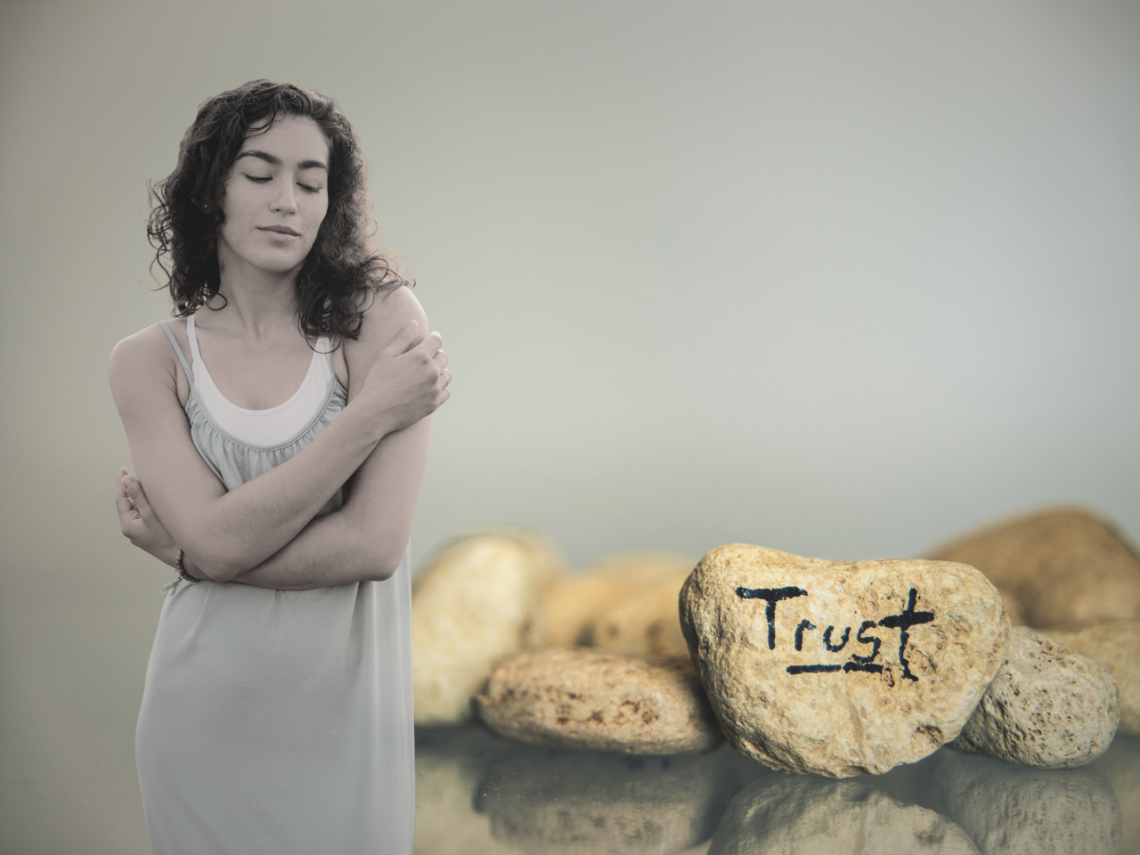 collage with stones with a text saying trust, and a female giving herself a hug.